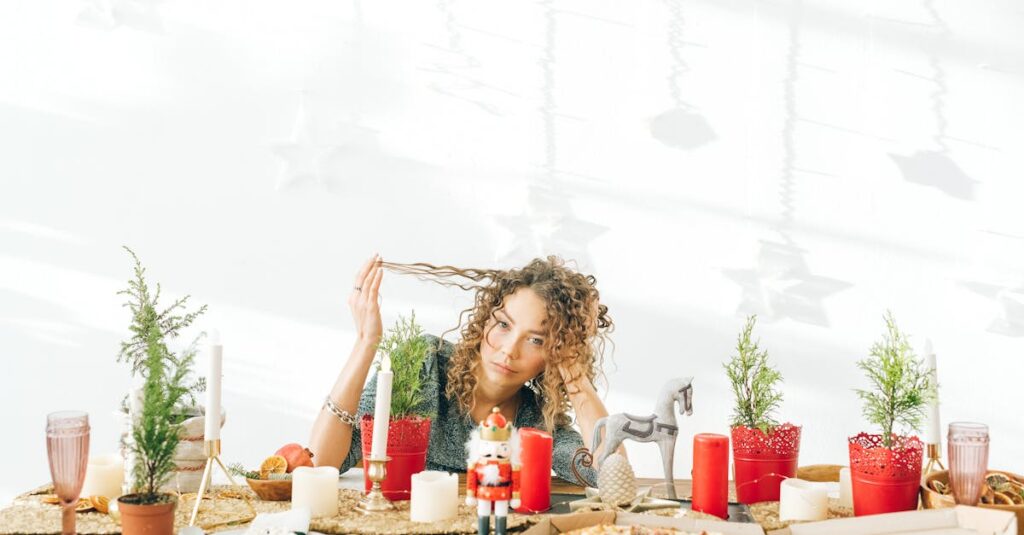 A woman with curly hair sits at a decorated dining table with candles and potted plants.