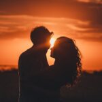 Romantic silhouette of a couple embracing at sunset, ideal for love and romance themes.