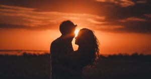 Romantic silhouette of a couple embracing at sunset, ideal for love and romance themes.